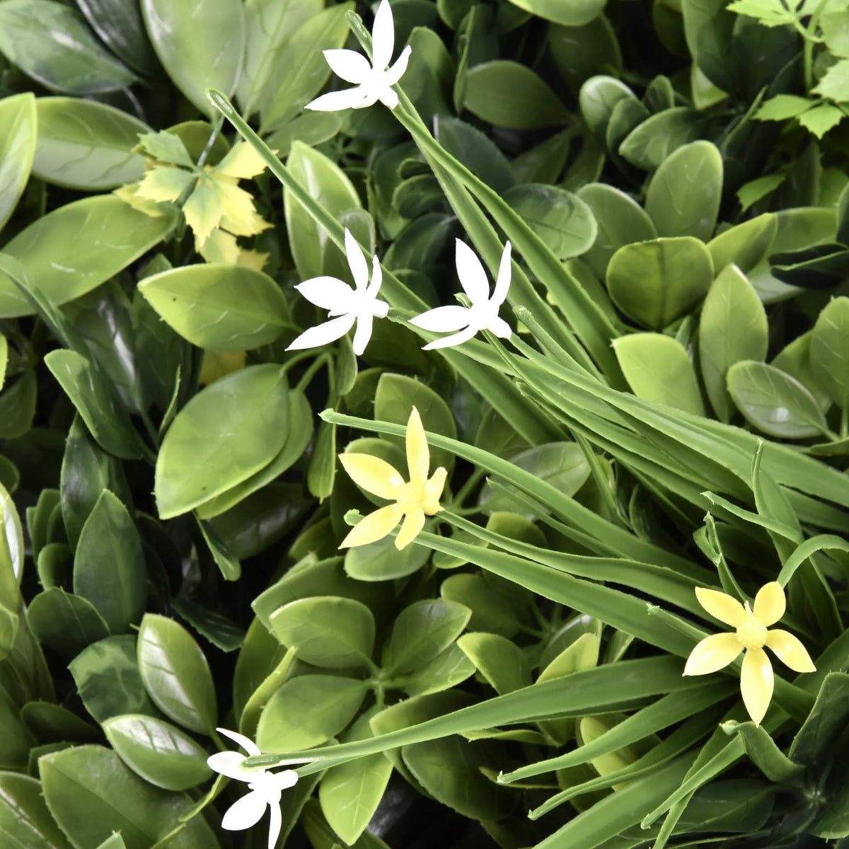 Gröna blad med små vita och gula blommor från Växtmatta LEAFLUXE WALL 2 från hjh LIVING