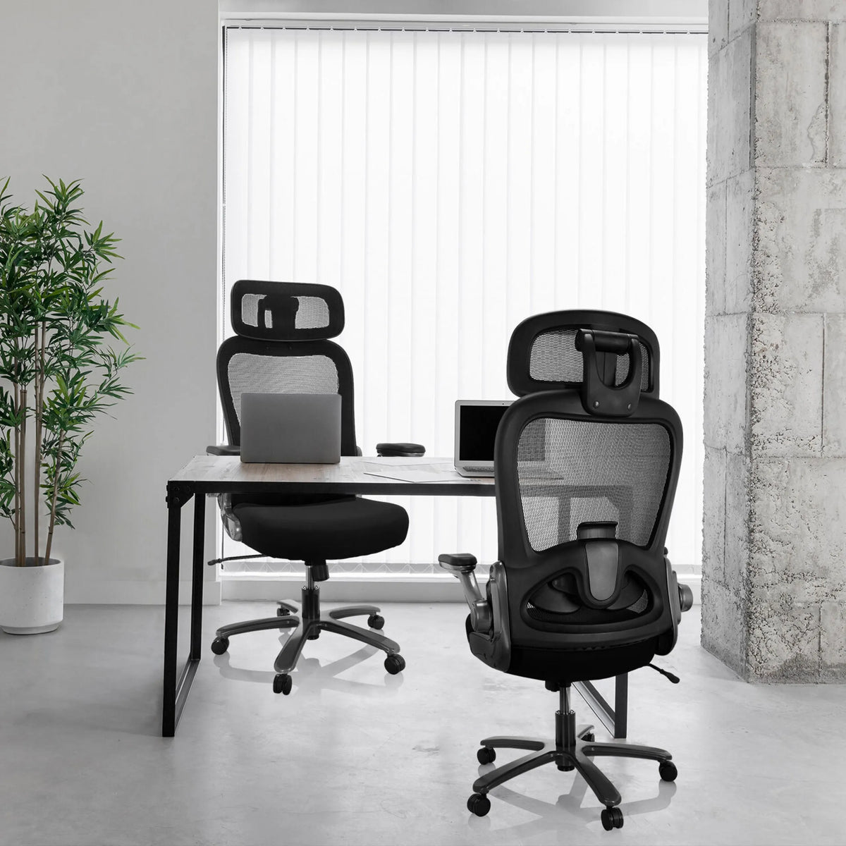 Två XXL snurrstolar INSTRUCTOR T I PRO med nätrygg och tygbeklädnad i svart vid ett skrivbord från hjh OFFICE