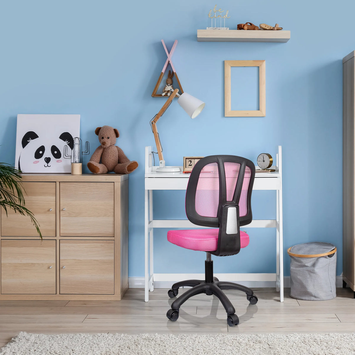 Rosa Snurrstol för barn KID YU 200 med nätrygg och hjul vid ett vitt skrivbord från hjh OFFICE