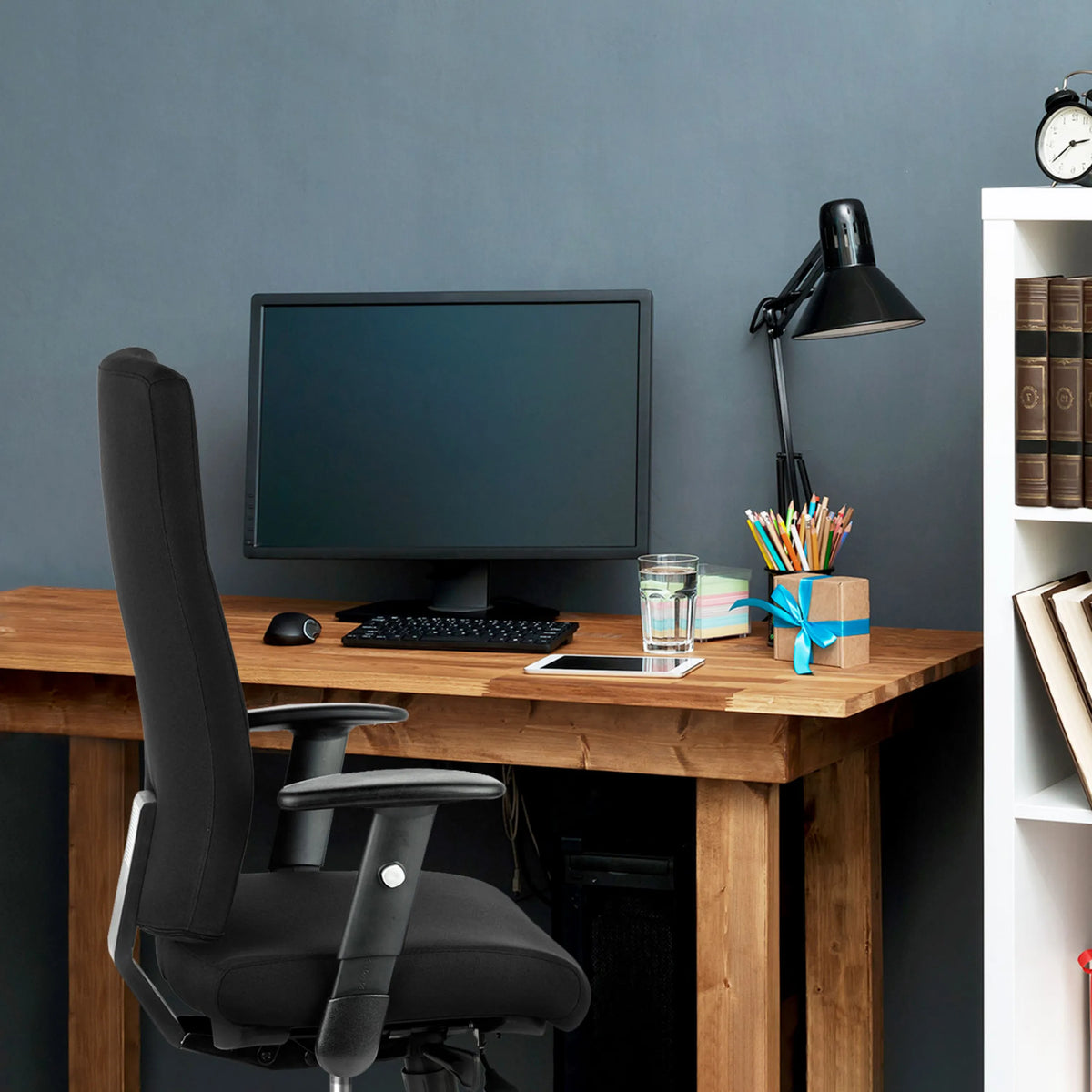 Svart Professionell kontorsstol PRO-TEC 300 med armstöd vid ett träbord från hjh OFFICE