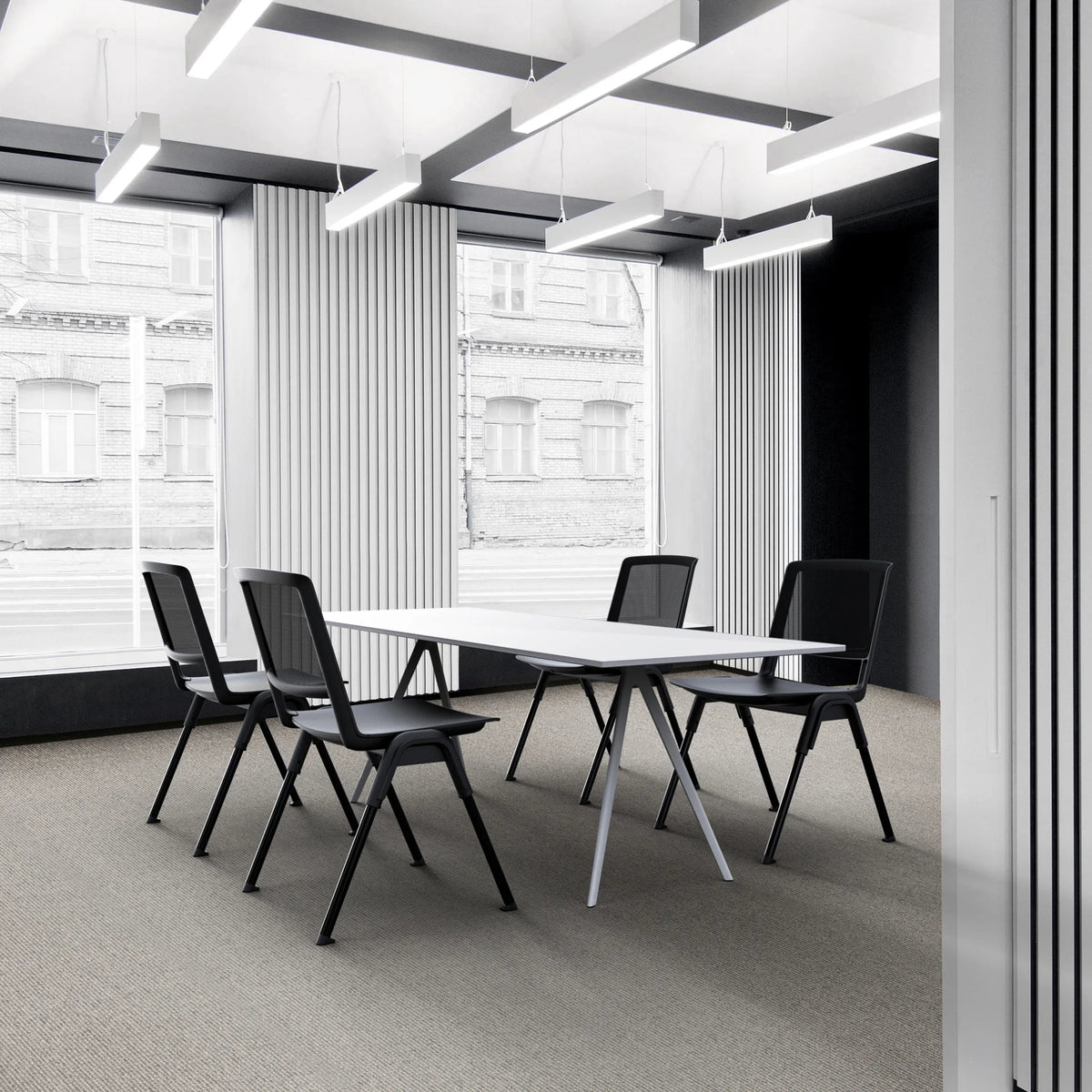 Fyra svarta MEET WA besökarstolar vid ett vitt konferensbord i ett modernt kontor från hjh OFFICE