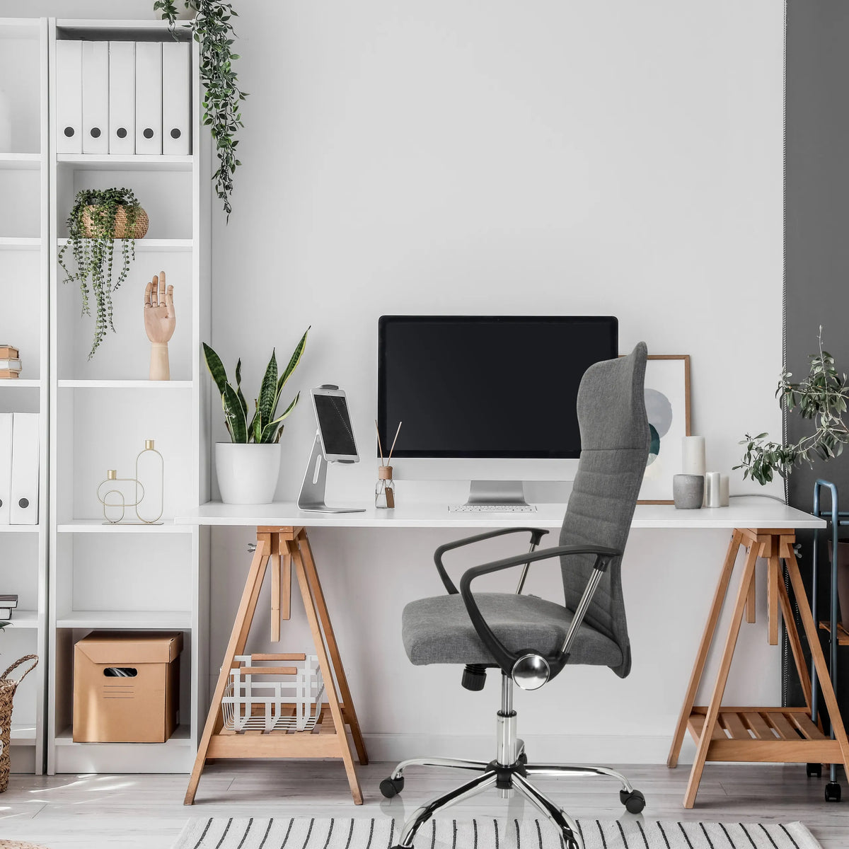Grå Home Office kontorsstol ARTON 40 med armstöd och hjul framför ett skrivbord från hjh OFFICE