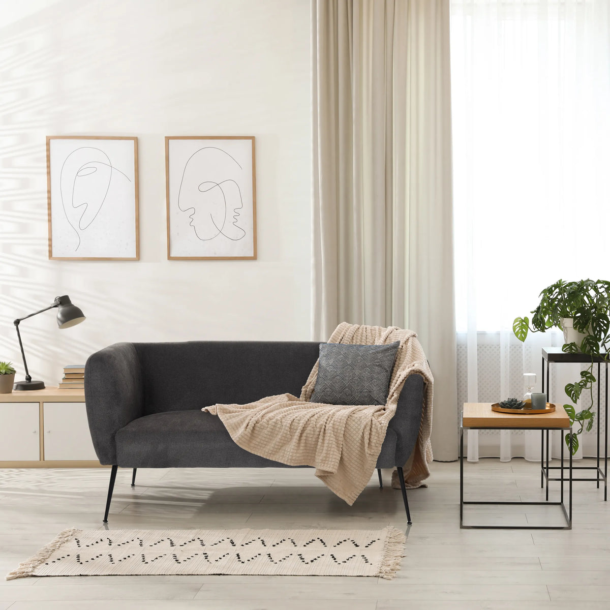 Grå Loungesoffa HAYRIVER med kuddar och filt i ett ljust rum från hjh LIVING