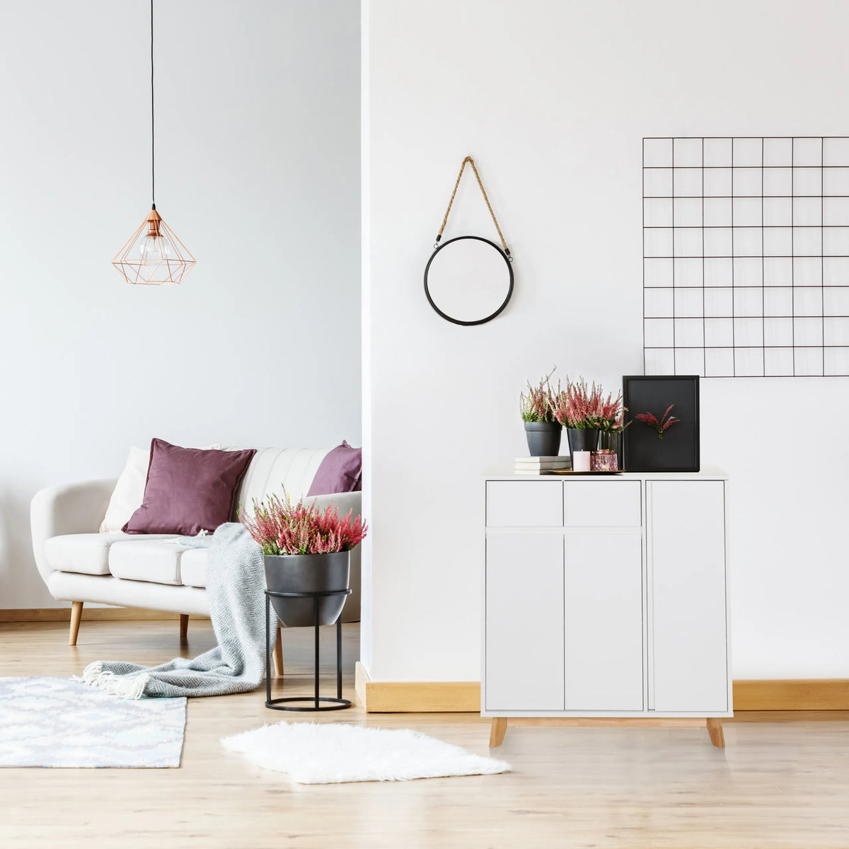 Vit byrå ESTHA med två dörrar och ljusa träben i ett ljust vardagsrum från hjh LIVING
