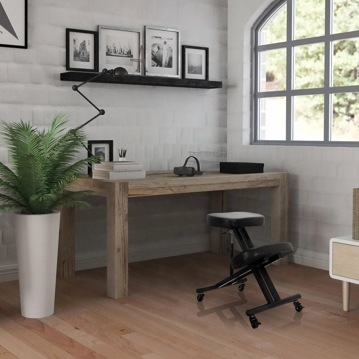Svart ORTHONI knäpall med hjul framför ett skrivbord i trä i ett ljust rum från hjh OFFICE