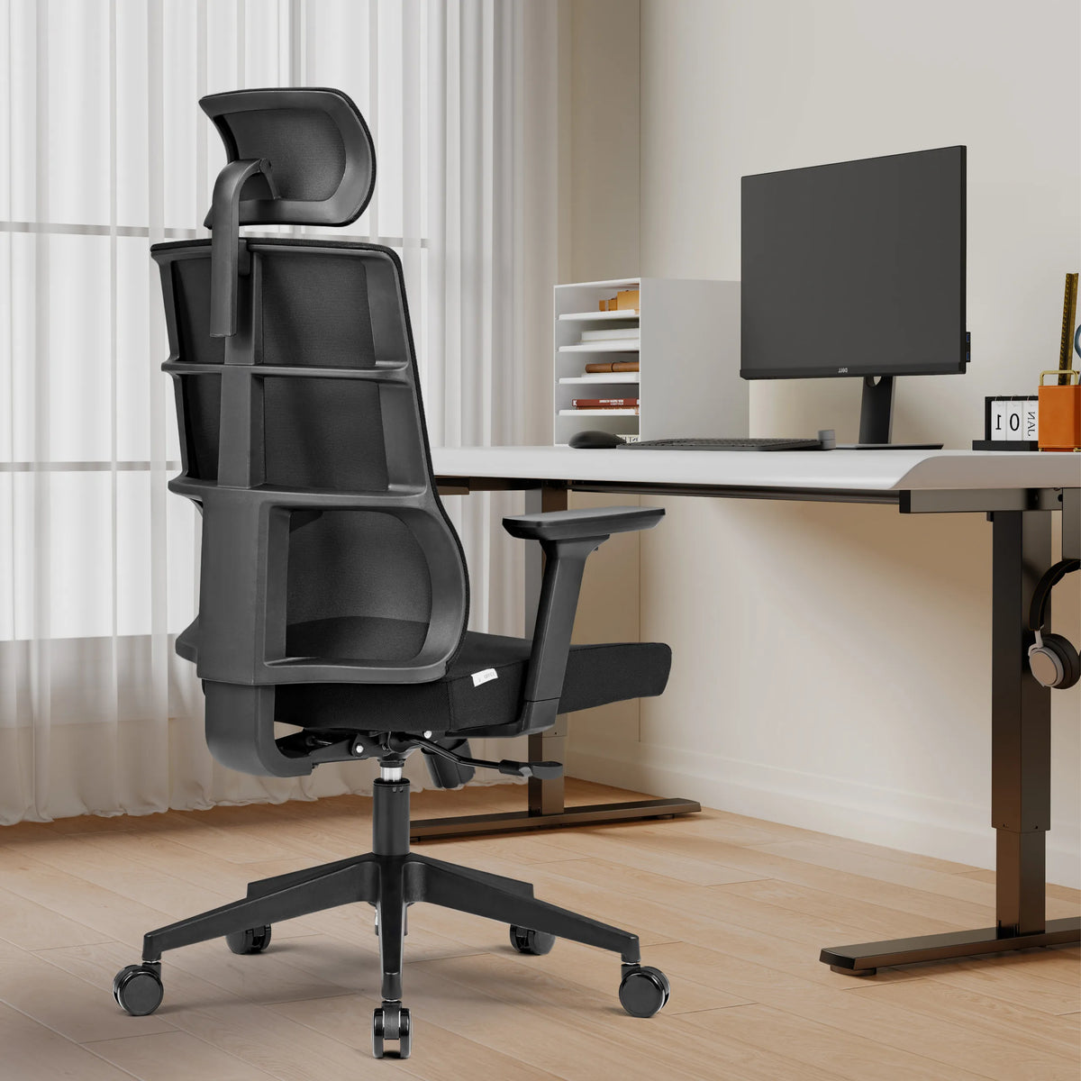 Svart Professionell kontorsstol SPINIO PRO med nackstöd och armstöd framför ett skrivbord från hjh OFFICE