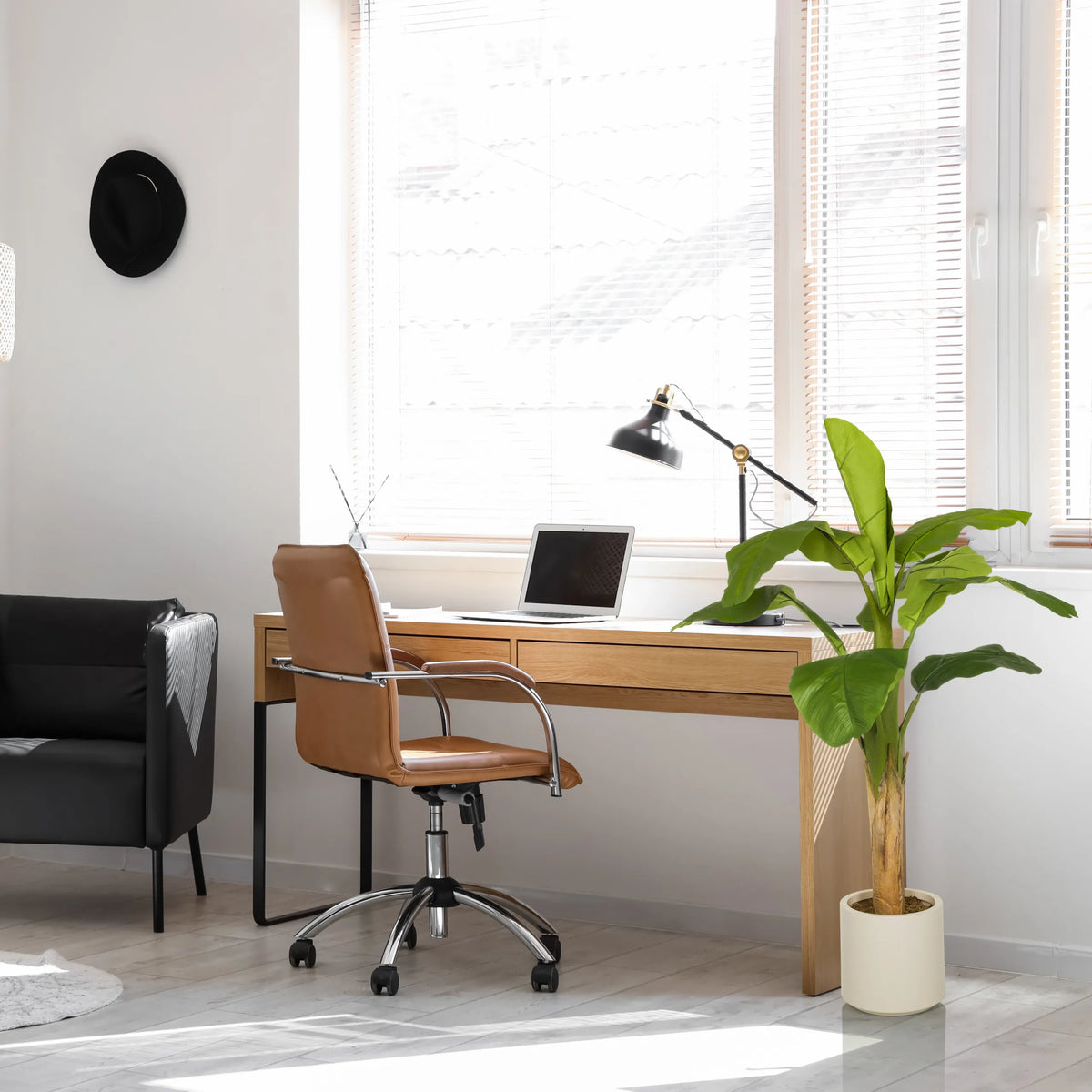 Grön konstgjord växt BANANE I i en ljus kruka bredvid ett skrivbord från hjh OFFICE