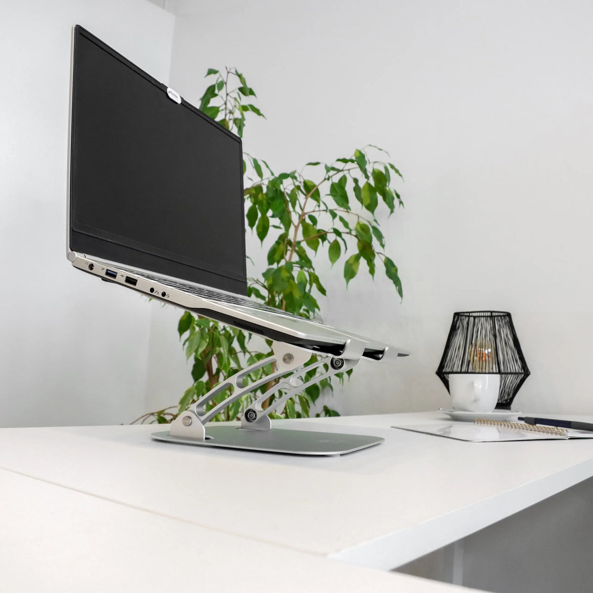 Silverfärgat LAPTOP STAND underlägg för bärbar dator med höjdjusterbart stativ och bärbar dator på ett vitt skrivbord från hjh OFFICE