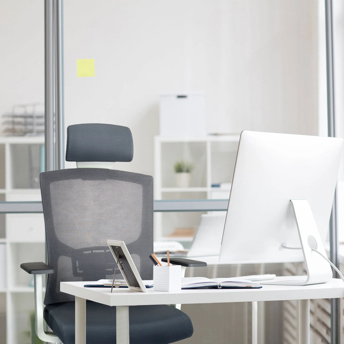 Grå Professionell kontorsstol CAPTIVO BASE W med nätryggstöd och nackstöd vid ett skrivbord från hjh OFFICE
