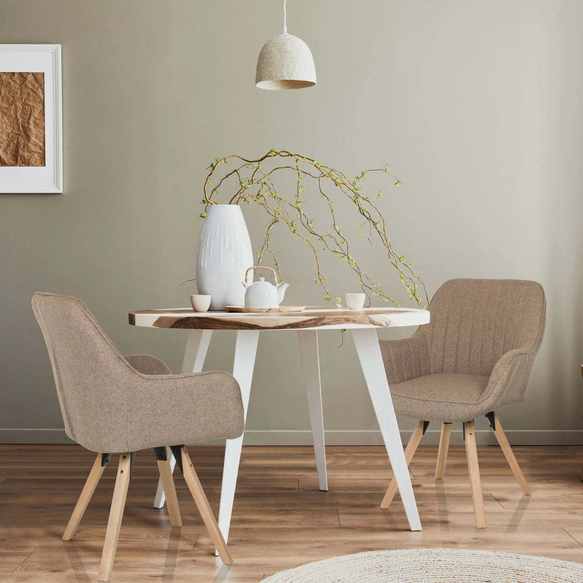 Två beige SCANDI SOFT stoppade stolar med träben vid ett runt matbord från hjh LIVING