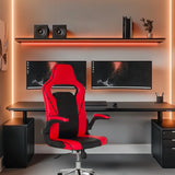 Spelstol GAME SPORT PRO i svart och rött vid ett skrivbord med två skärmar från MyBuero