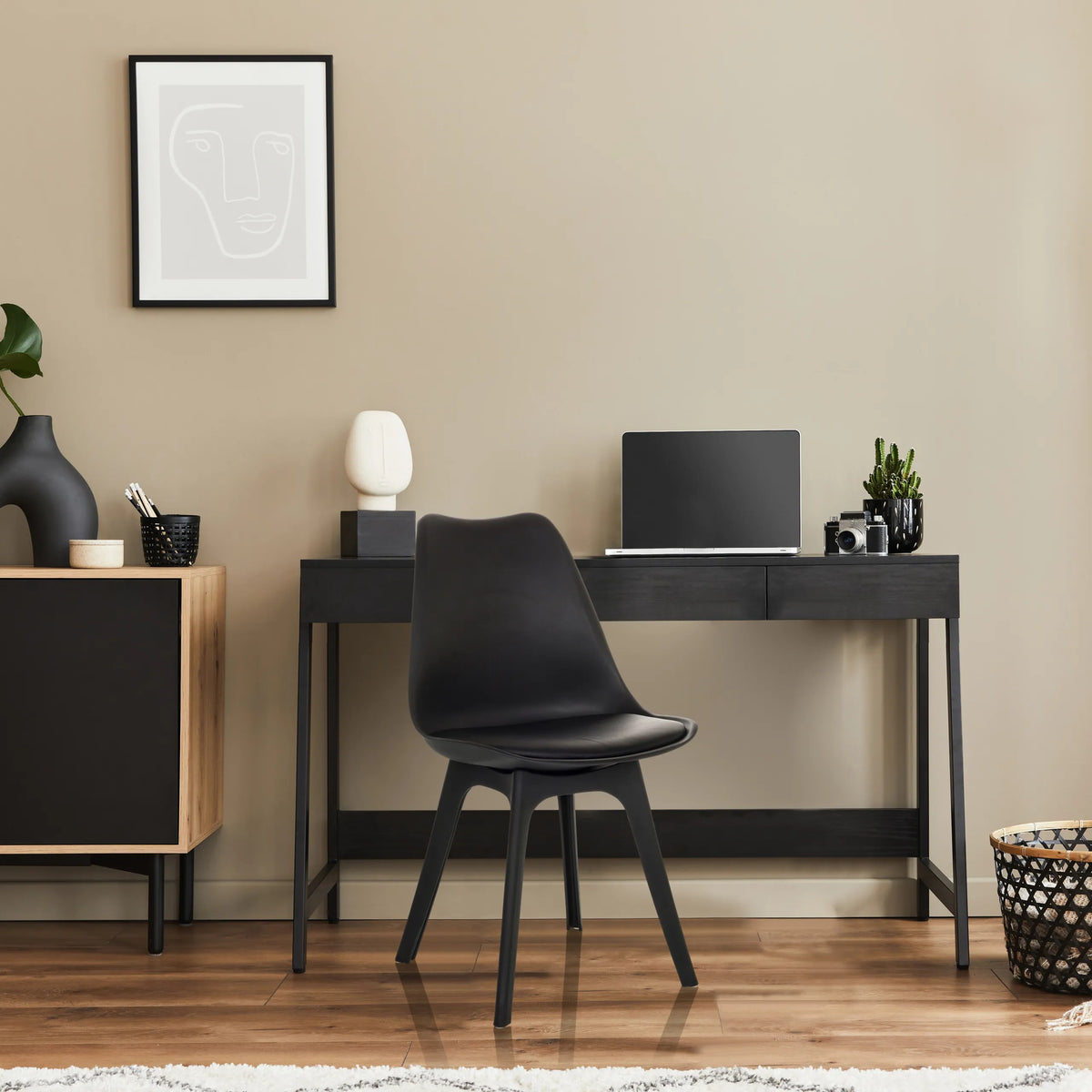 Skålformad stol SCANDI P i svart med fyra ben framför ett skrivbord från hjh OFFICE