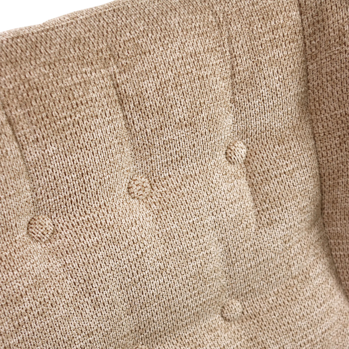 Beige vävd textil med knappstoppning på den stoppade fåtöljen HAVENIO från hjh LIVING