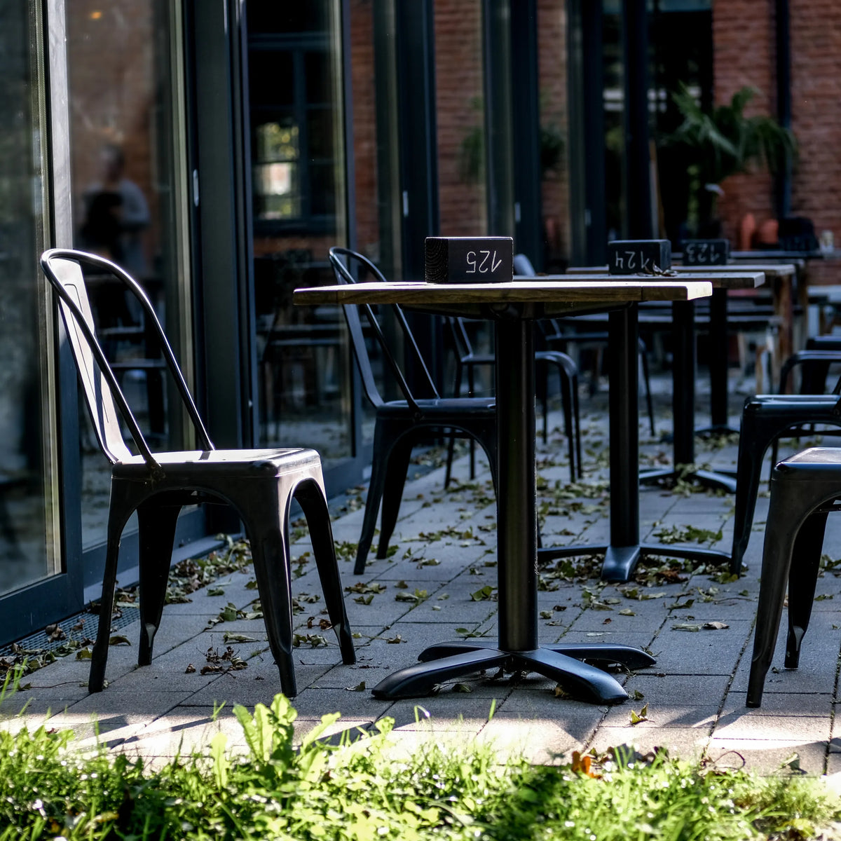 Svart Bistrostol VANTAGGIO BRUSH med matchande bord i utomhusmiljö från hjh OFFICE