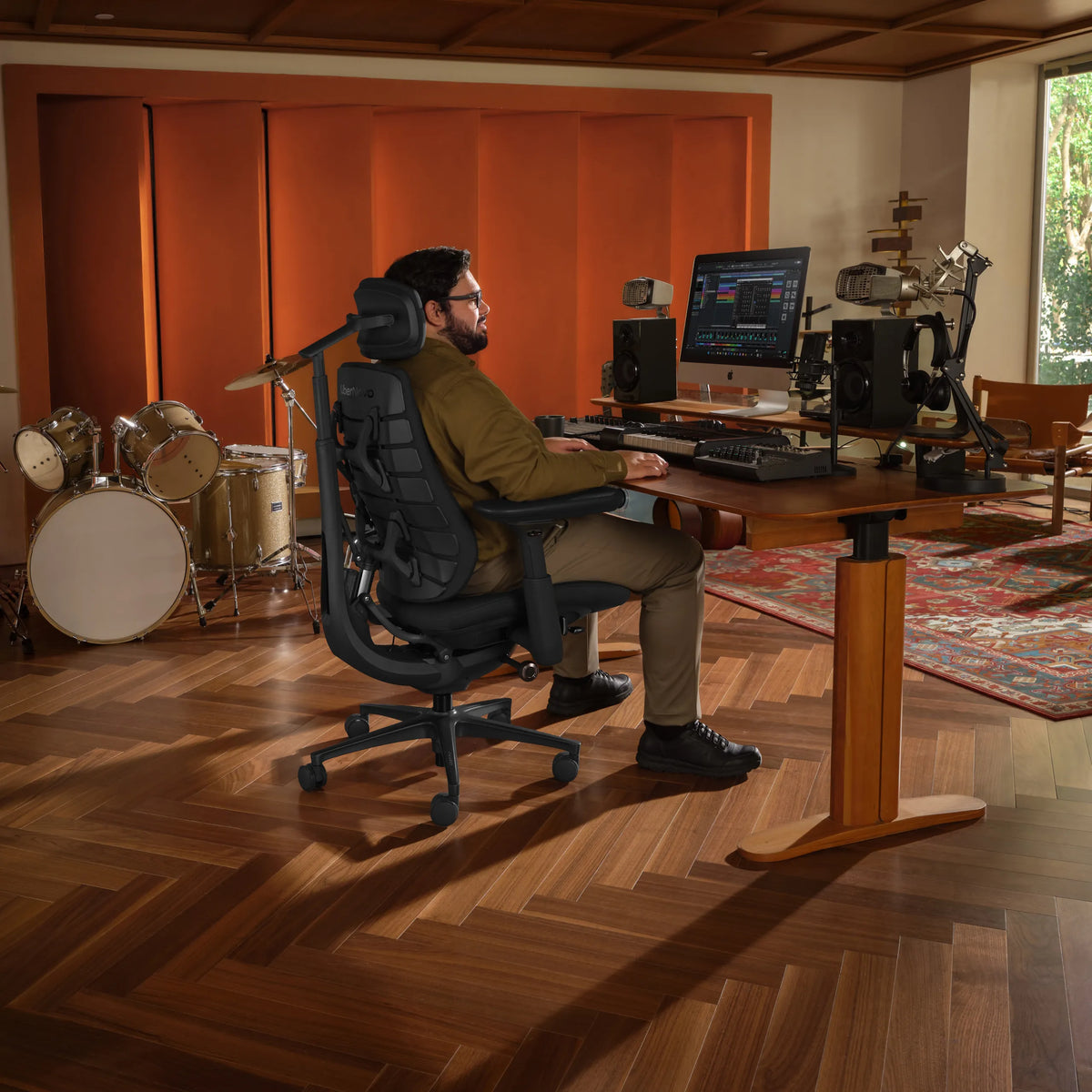 Kontorsstol LiberNovo Maxis Airflow i grafit vid ett höj- och sänkbart skrivbord i en musikstudio från Libernovo