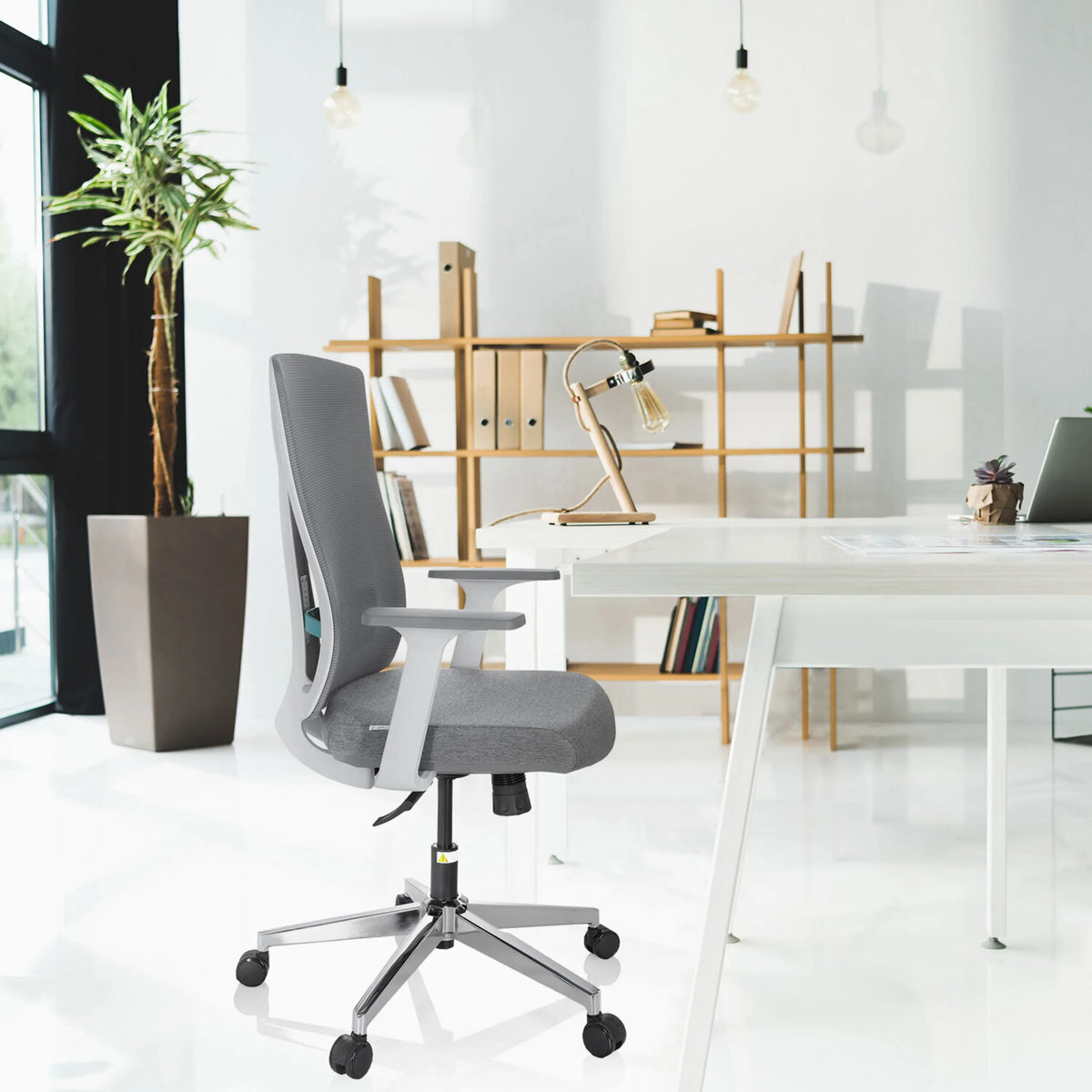 Grå professionell kontorsstol HALIFAX med nätryggstöd och armstöd vid ett vitt skrivbord från hjh OFFICE