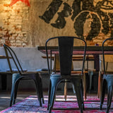 Baksidan av en svart VANTAGGIO BRUSH bistrostol i metall vid ett bord från hjh OFFICE