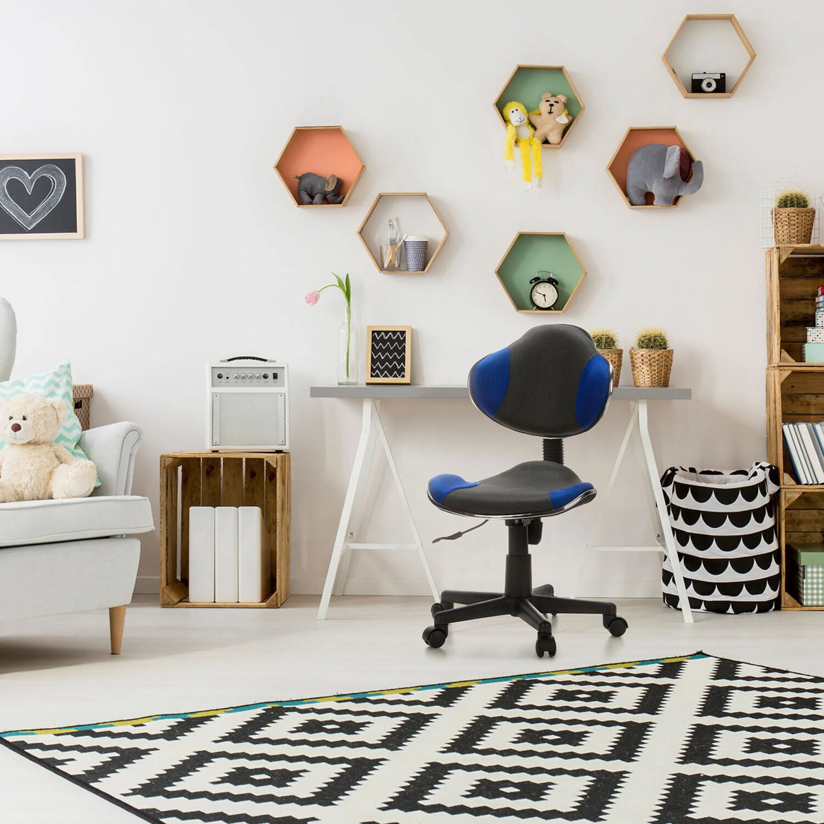 Snurrstol för barn KIDDY GTI-2 i grått och blått med hjulkors framför ett skrivbord från hjh OFFICE