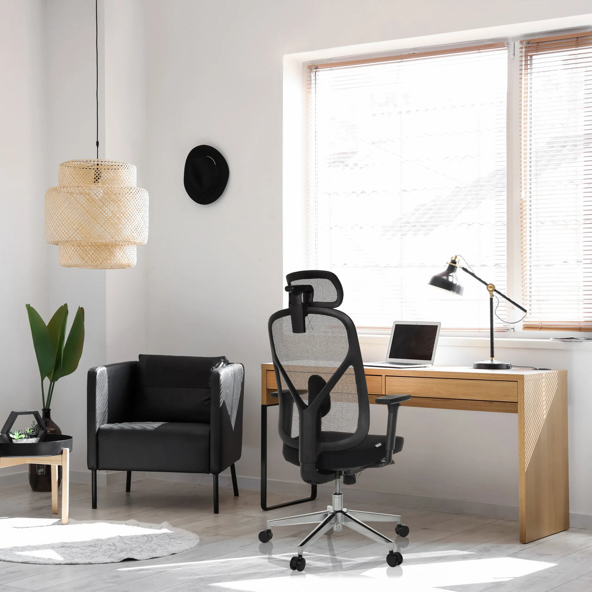 Professionell kontorsstol RALOO PRO i svart med nätryggstöd och nackstöd vid ett skrivbord från hjh OFFICE