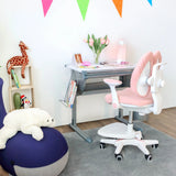 Rosa barnstol KID WING med vit ram och hjul framför ett barnskrivbord från hjh OFFICE