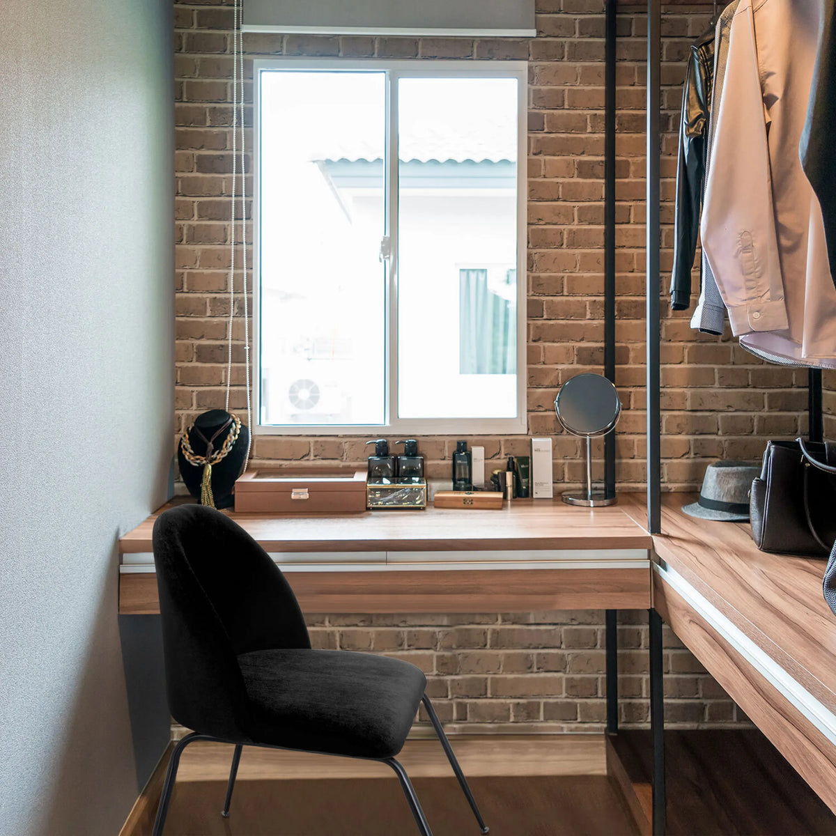 Svart stoppad stol VELVO med smala metallben framför ett sminkbord i trä från hjh OFFICE