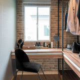 Svart stoppad stol VELVO med smala metallben framför ett sminkbord i trä från hjh OFFICE