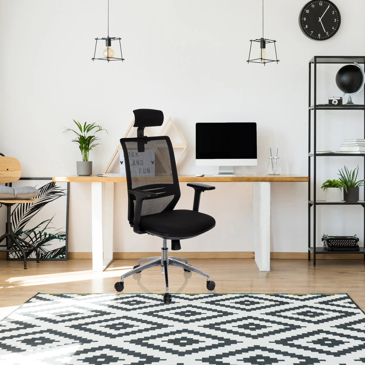 Professionell kontorsstol PROFONDO PRO i svart med nätryggstöd och nackstöd framför ett skrivbord från hjh OFFICE