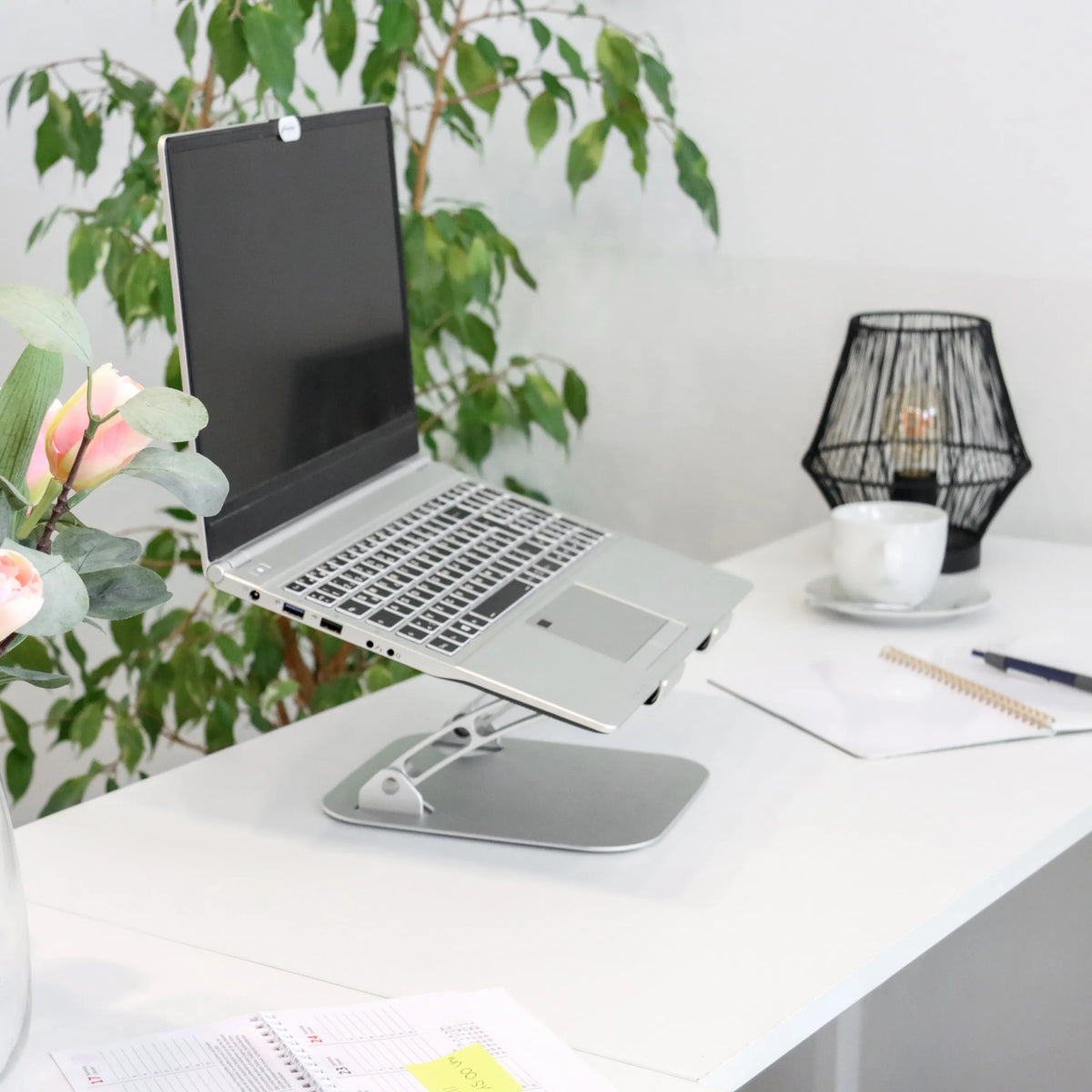 Silverfärgat underlägg för bärbar dator LAPTOP STAND med justerbart stativ på ett vitt skrivbord från hjh OFFICE