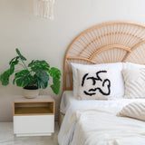 Vitt sidobord MELMO med öppen hylla i eklook bredvid en säng från hjh LIVING