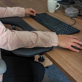 Svart armstöd av modellen RELEX RT2 på ett skrivbord med tangentbord och mus från hjh OFFICE