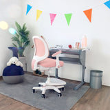 Rosa barnstol KID ERGO med vita armstöd och hjul vid ett skrivbord från hjh OFFICE