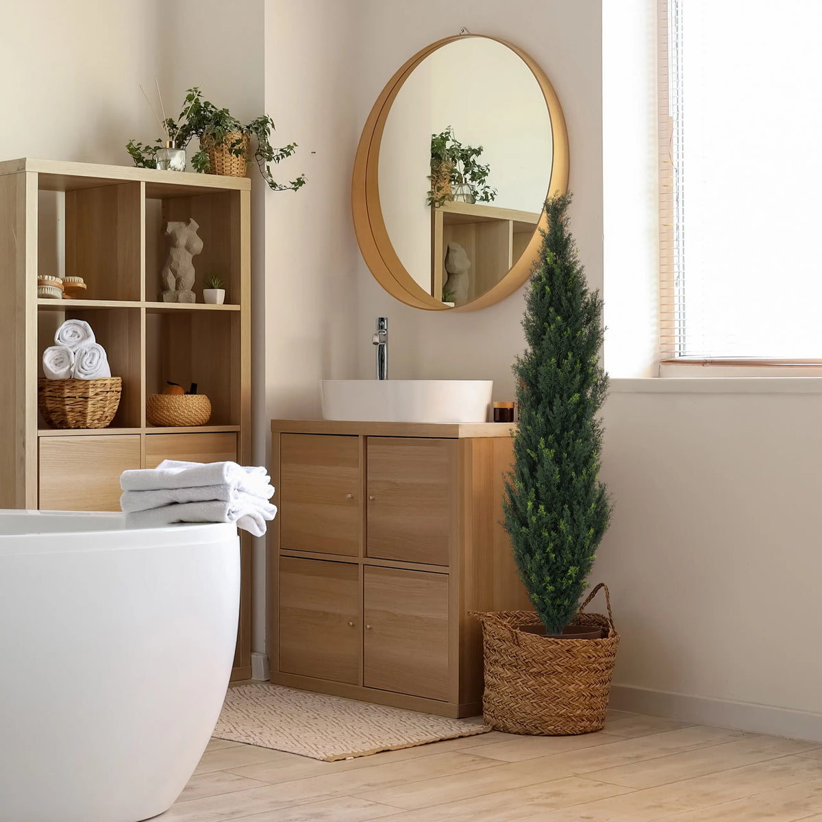 Grön konstgjorda växter CEDRUS i en flätad korg bredvid ett badrumsskåp från hjh OFFICE