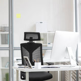 Svart Professionell kontorsstol KODIAK med nätryggstöd och nackstöd vid ett vitt skrivbord från hjh OFFICE