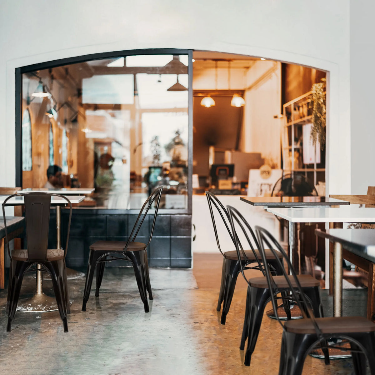 Svarta Bistrostolar VANTAGGIO COMFORT W med metallram vid bord i ett café från hjh OFFICE