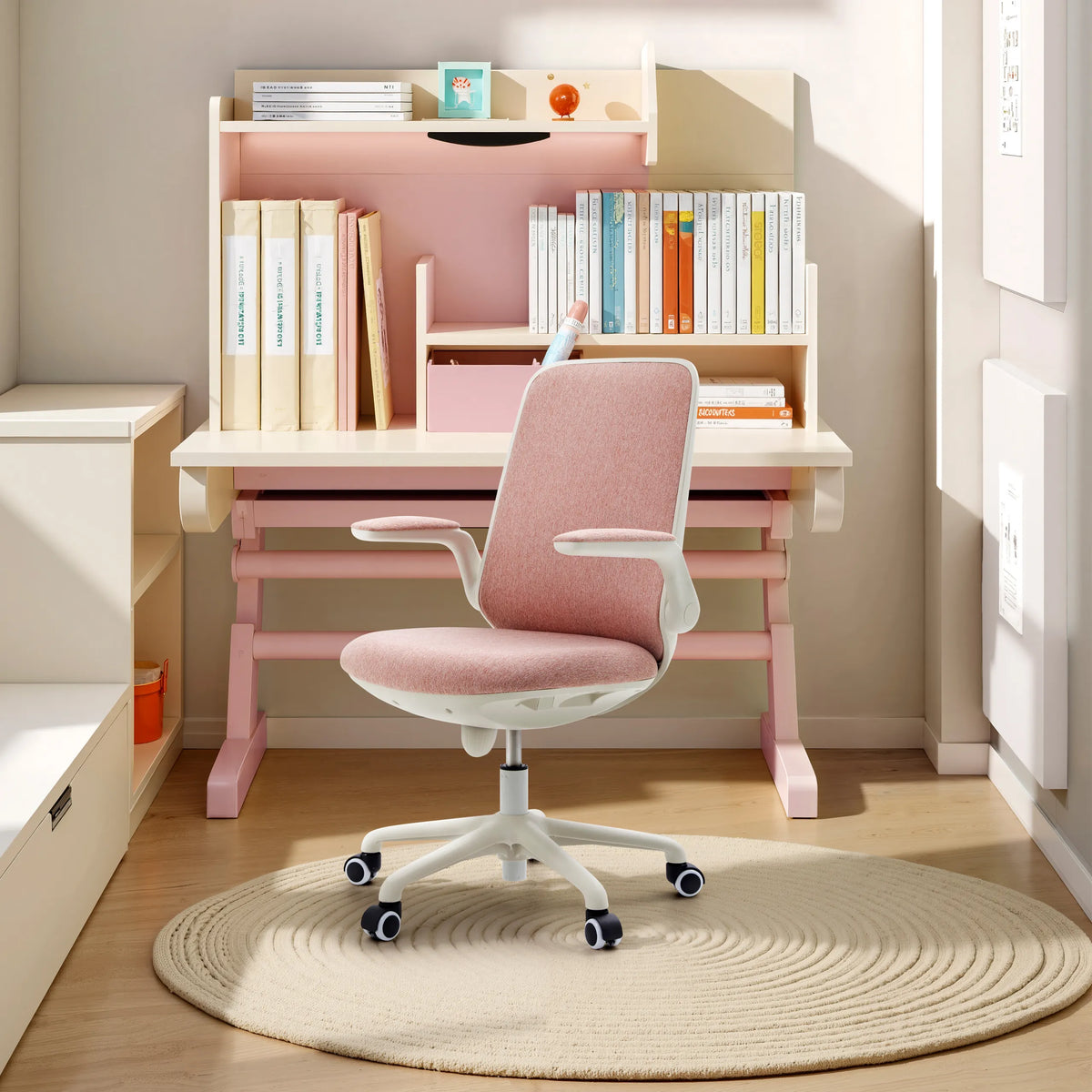 Rosa Snurrstol för barn Swivelo med armstöd och hjul vid ett skrivbord från hjh OFFICE